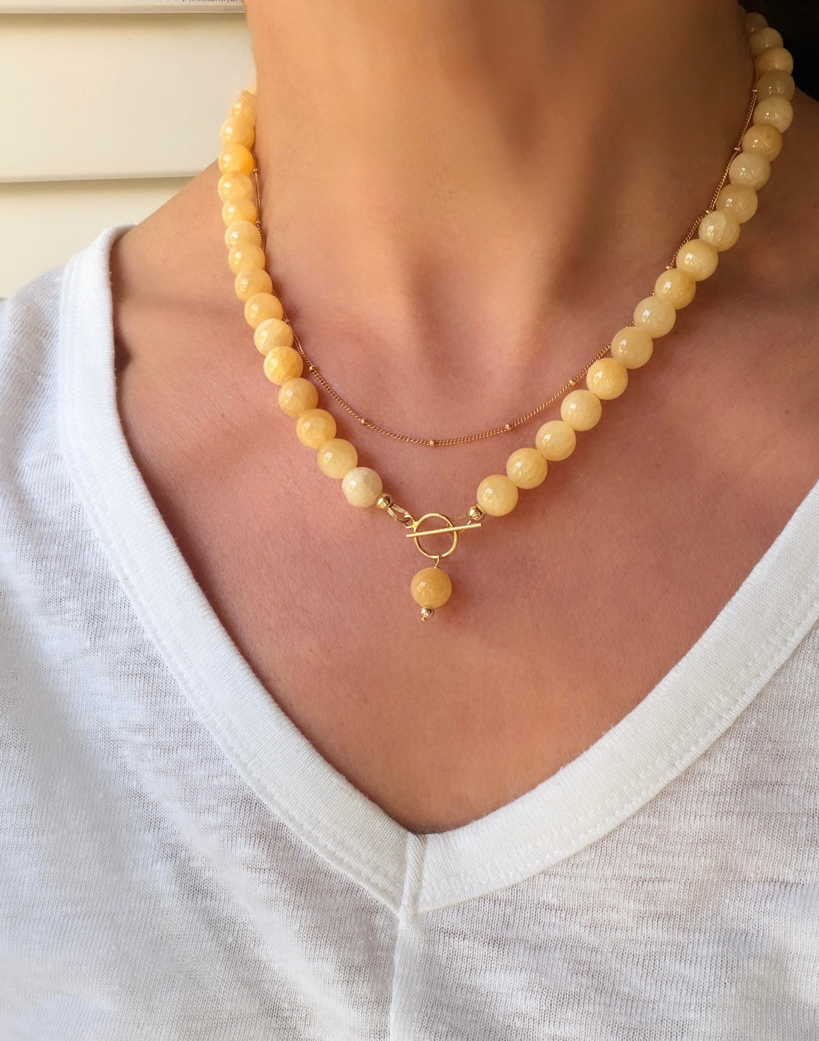 This beautiful Honey jade beaded necklace is the perfect accessory for the Spring/Summer season.
The necklace is finished with a toggle clasp with a dangle bead, in either a Gold filled or Sterling Silver finish. The necklace length is approximately 17”