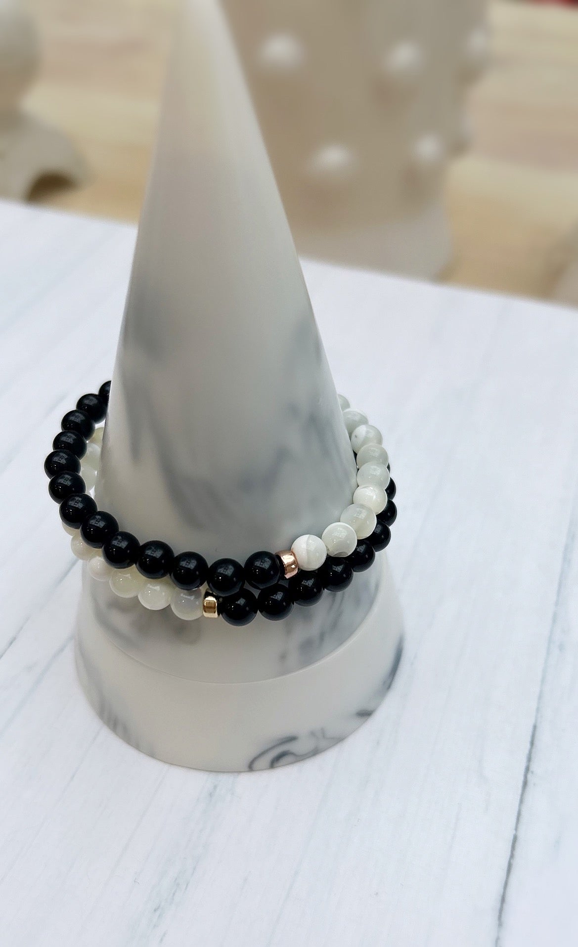 A striking black and white duo bracelet with Black Onyx and Mother of Pearl beads threaded on a stretch cord. 